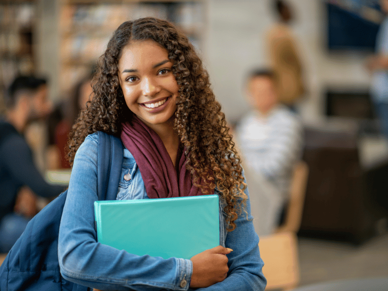 Female student smiling at the camera. Expand your global horizons with the Oxford International School Immersion Programme.